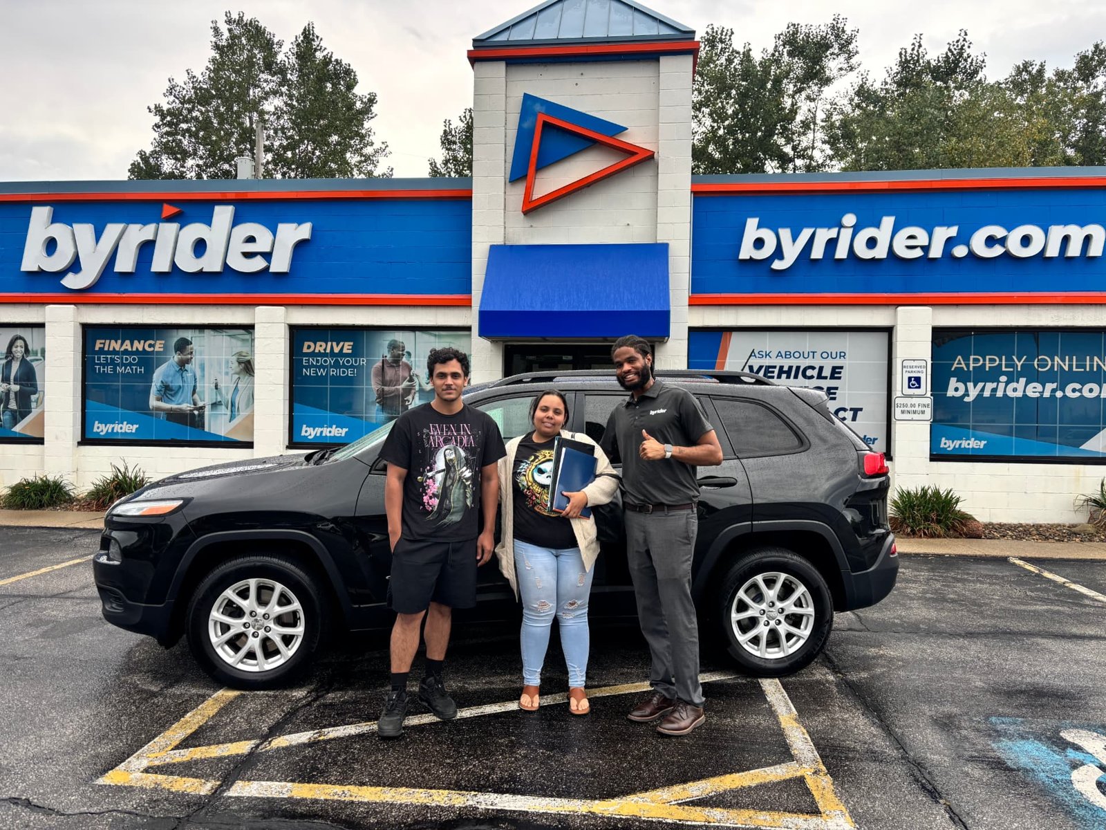 Byrider Amherst customers and salesperson with their used Jeep Cherokee at the Amherst, Ohio dealership