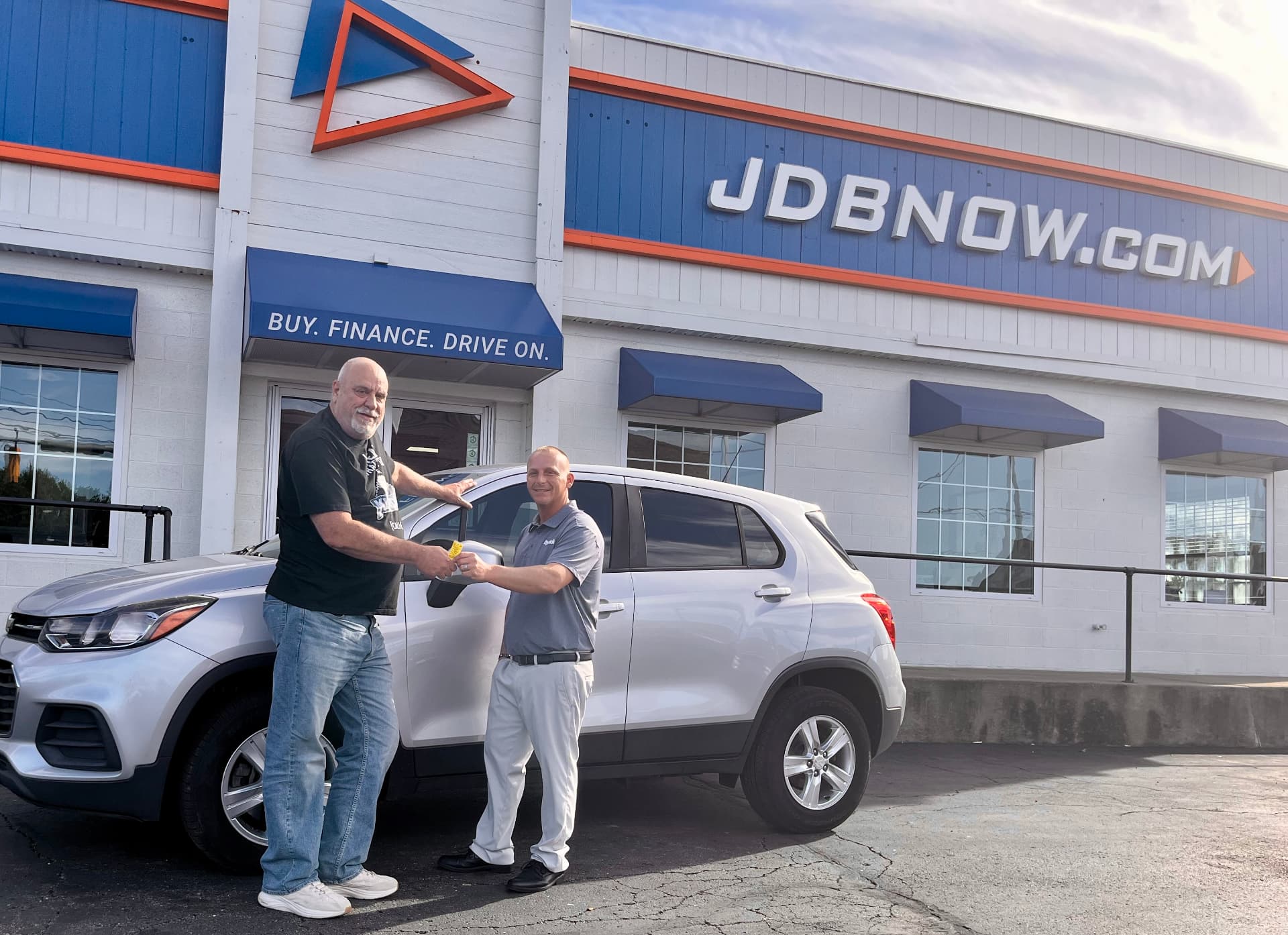 Byrider Canton customer and salesperson beside their used Chevrolet Trax at the Canton, Ohio dealership
