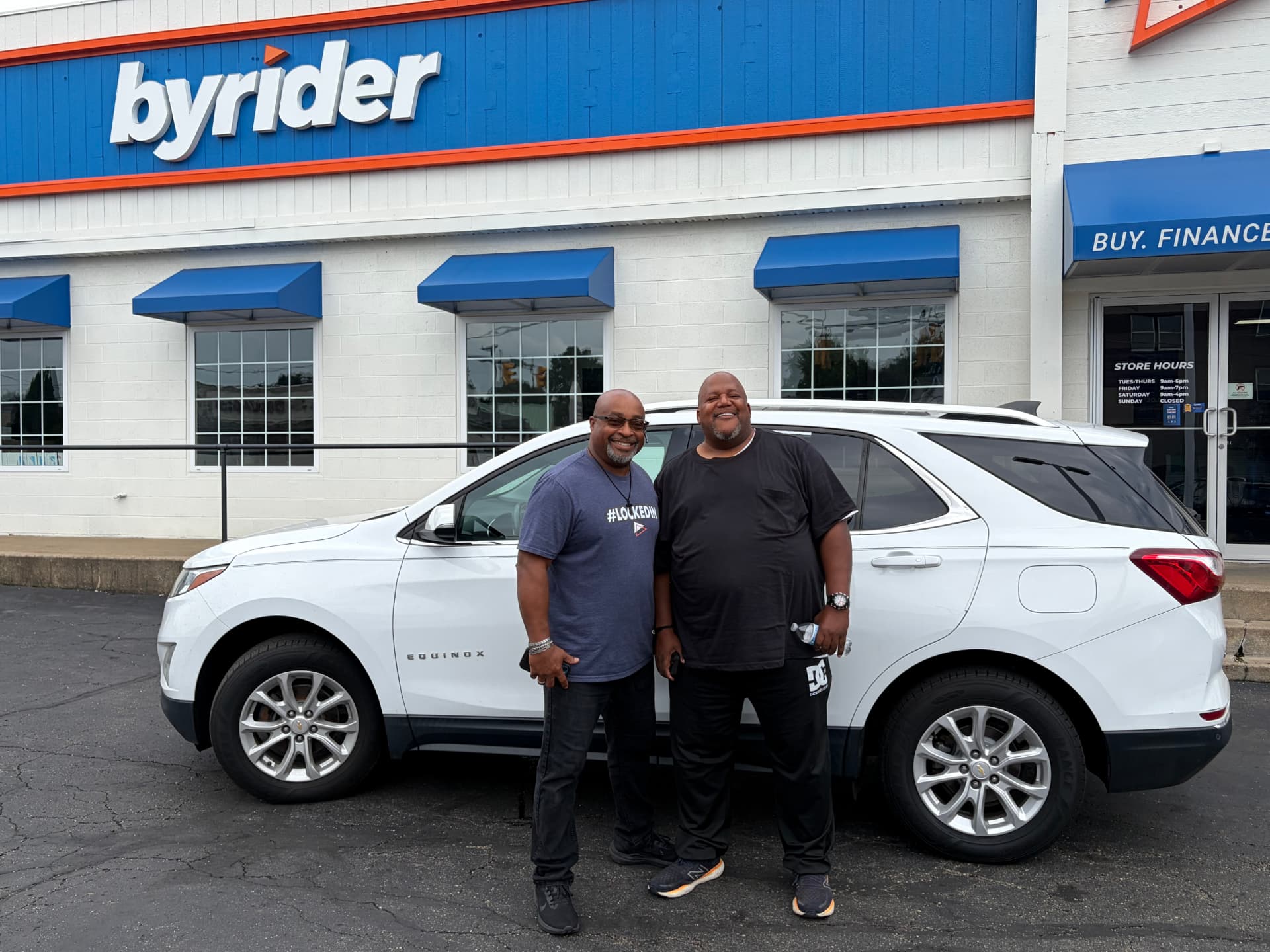 Byrider Canton customers beside their used Chevrolet Equinox at the Canton, Ohio dealership