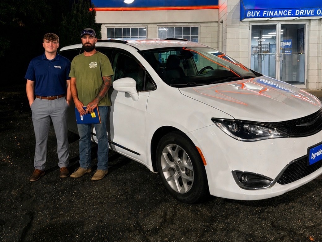 Byrider Wooster customer and salesperson beside their used Chrysler Pacifica at the Wooster, Ohio dealership